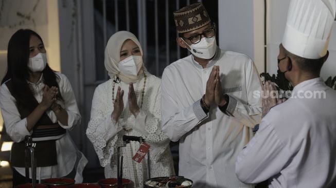 Menteri Pariwisata dan Ekonomi Kreatif Sandiaga Uno (kedua kanan) didampingi istrinya Nur Asia (kedua kiri) dan Chef Reuben Endro Winantyo (kanan) memberikan tanggapan pada makanan yang dihidangkan untuk berbuka puasa saat program Selera Ramadhan di Nur Corner, Kebayoran Baru, Jakarta, Senin (3/5/2021). [Suara.com/Angga Budhiyanto]