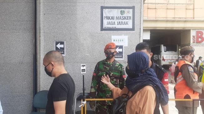 Penjagaan aparat di pintu masuk di Pasar Tanah Abang, Jakpus. (Suara.com/Yaumal)