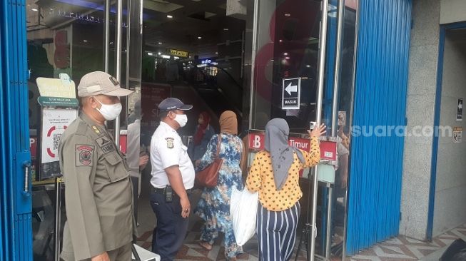 Penjagaan aparat Satpol PP di pintu masuk di Pasar Tanah Abang, Jakpus. (Suara.com/Yaumal)