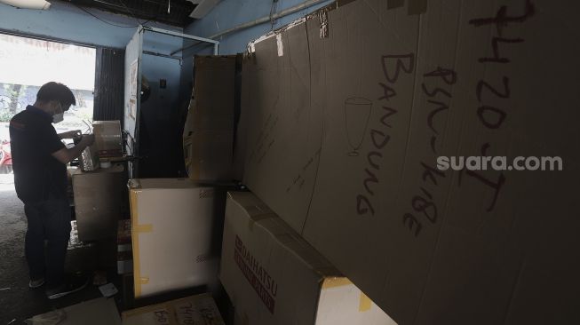 Pekerja mengemas barang yang akan dikirim via jasa ekspedisi kereta api di Jalan Bungur Raya, Senen, Jakarta, Selasa (4/5/2021). [Suara.com/Angga Budhiyanto]