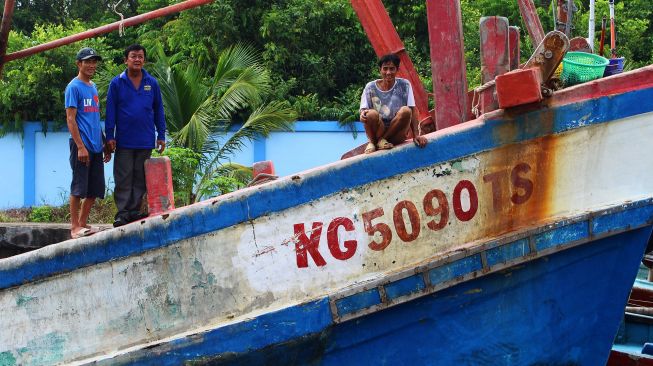 Tiga awak kapal berkewarganegaraan Vietnam berdiri di atas kapal di dermaga Stasiun Pengawasan Sumber Daya Kelautan dan Perikanan (PSDKP) Pontianak di Kabupaten Kubu Raya, Kalimantan Barat, Selasa (4/5/2021). ANTARA FOTO/Jessica Helena Wuysang