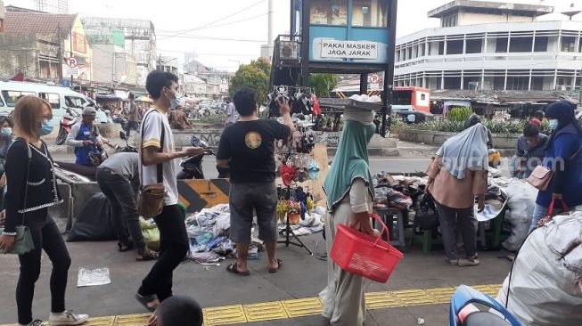 Pedagang Kaki Lima mengelar barang dagangannya di trotoar Pasar Tanah Abang. (Suara.com/Yaumal)