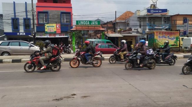 Sejumlah pemudik menggunakan sepeda motor melintasi Jalan Raya Bandung-Garut, Kabupaten Bandung, Jawa Barat, Rabu (5/5/2021). [ANTARA/Bagus Ahmad Rizaldi]