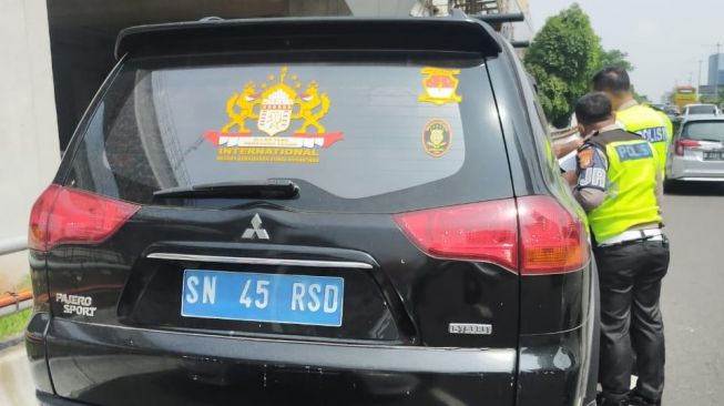 Pengemudi mobil Mitsubishi Pajero Sport bernama Rusdi Karepesina memakai plat nomor palsu SN 45 RSD ditilang polisi di Gerbang Tol Cawang, Jakarta Timur, Rabu (5/5/2021). Kepada polisi dia mengaku warga warga Negara Kekaisaran Sunda Nusantara. (Dok. Ist)