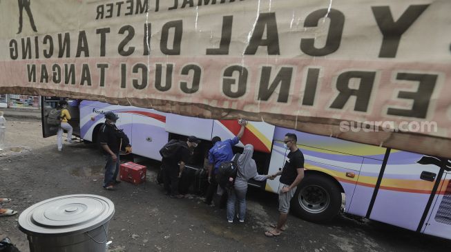 Sejumlah calon penumpang memasukkan barang bawaannya ke dalam bagasi bus di Terminal Lebak Bulus, Jakarta, Rabu (5/5/2021). [Suara.com/Angga Budhiyanto]