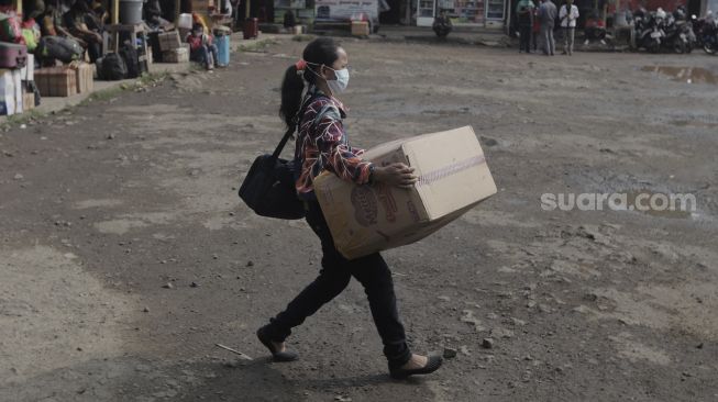 Calon penumpang membawa barang bawaannya berjalan menuju bus di Terminal Lebak Bulus, Jakarta, Rabu (5/5/2021). [Suara.com/Angga Budhiyanto]