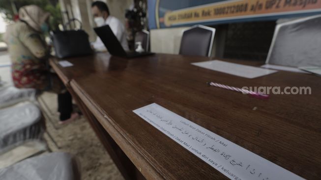 Kertas bertuliskan niat berzakat terpasang untuk memudahkan Umat Islam yang akan membayar zakat fitrah kepada amil zakat di Masjid Istiqlal, Jakarta, Rabu (5/5/2021). [Suara.com/Angga Budhiyanto]