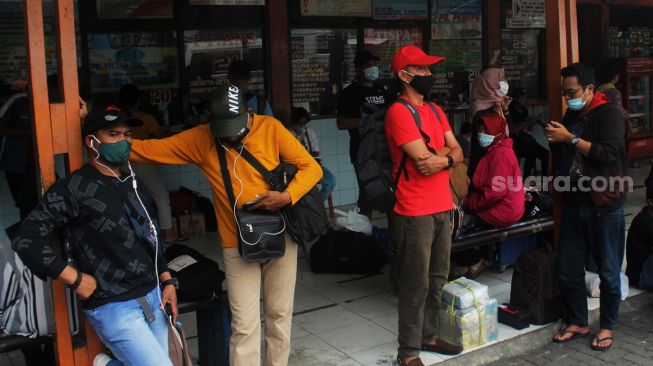 Calon pemudik menunggu kedatangan Bus di Terminal Kalideres, Jakarta, Rabu (5/5/2021).  [Suara.com/Dian Latifah]

