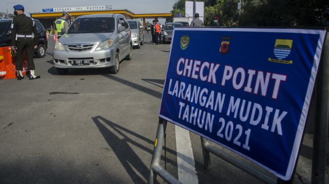 Petugas gabungan melakukan pemeriksaan kelengkapan administrasi pengendara saat penyekatan larangan mudik lebaran di Gerbang Tol Pasteur, Bandung, Jawa Barat, Kamis (6/5/2021).  ANTARA FOTO/Novrian Arbi
