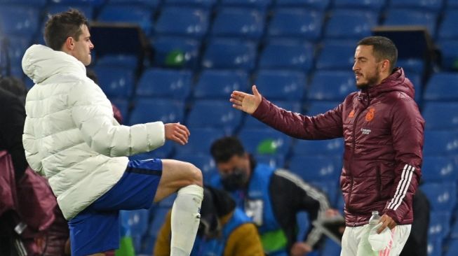 Penyerang Real Madrid Eden Hazard bersalaman dengan kapten Chelsea Cesar Azpilicueta usai timnya kalah 0-2 dalam laga leg kedua babak semifinal Liga Champions di Stamford Bridge, London, Kamis (6/5/2021) dini hari WIB. [Glyn KIRK / AFP].