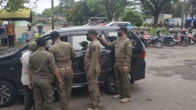 Petugas melakukan pemeriksaan di titik penyekatan Pontianak. (Antara/Andilala)