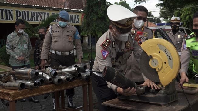 Petugas memusnahkan barang bukti knalpot brong di Polresta Banyumas, Jateng, Jumat (7/5/2021).ANTARA FOTO/Idhad Zakaria