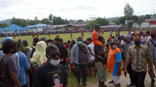 Warga berkerumun menyaksikan pertandingan sepak bola di Lapangan Hoki Sorong, Papua Barat, Jumat (7/5/2021). ANTARA FOTO/Olha Mulalinda