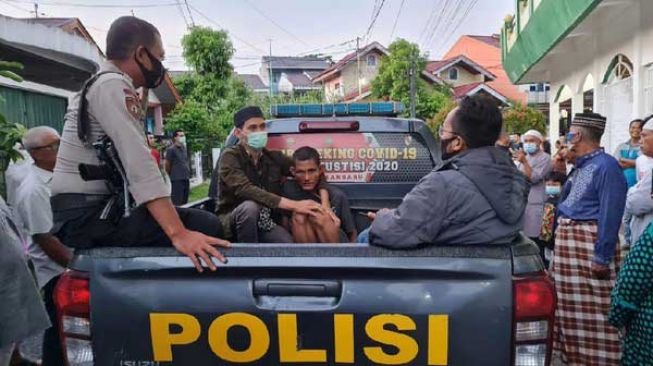 Pelaku pemukul imam masjid di Pekanbaru dibawa polisi. [Dok polisi]