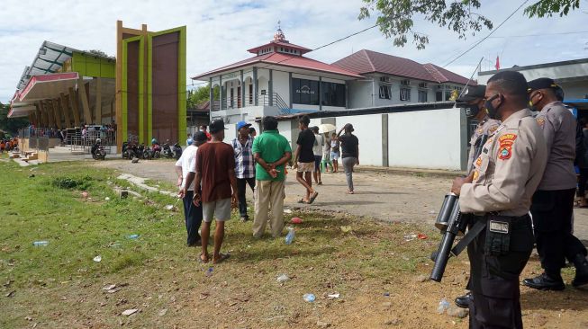 Petugas kepolisian berjaga saat membubarkan kerumunan warga yang menyaksikan pertandingan sepak bola di Lapangan Hoki Sorong, Papua Barat, Jumat (7/5/2021). ANTARA FOTO/Olha Mulalinda