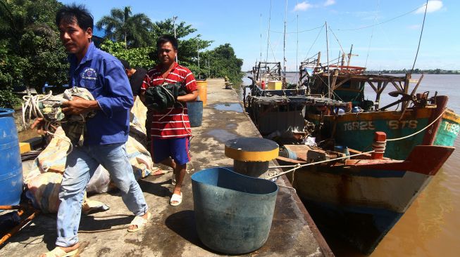 Dua awak kapal berkewarganegaraan Vietnam membawa barang mereka yang diturunkan dari kapal tangkapan di dermaga Stasiun Pengawasan Sumber Daya Kelautan dan Perikanan (PSDKP) Pontianak di Kabupaten Kubu Raya, Kalimantan Barat, Sabtu (8/5/2021).  ANTARA FOTO/Jessica Helena Wuysang