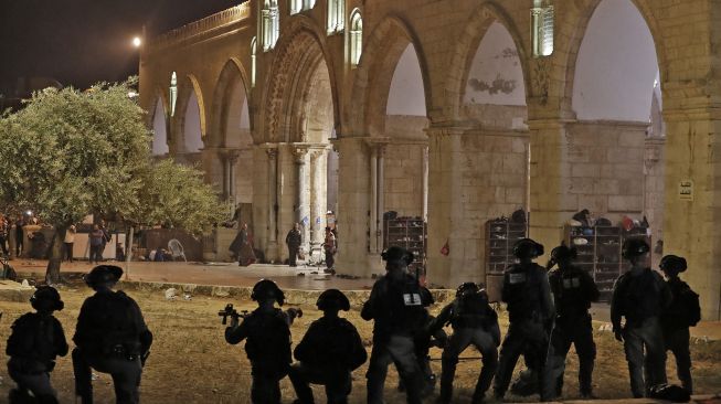 Polisi Israel berkumpul saat bentrokan dengan warga Palestina di kompleks Masjid Al Aqsa, di  Yerusalem, (7/5/2021). Ahmad GHARABLI / AFP
