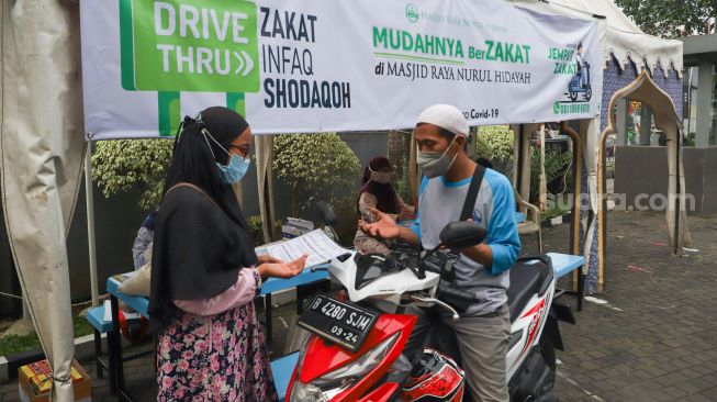 Warga membayar zakat secara drive thru di Masjid Nurul Hidayah, Tanah Kusir, Jakarta Selatan, Sabtu (8/5/2021). [Suara.com/Alfian Winanto]