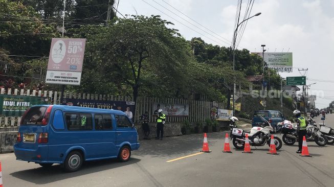 Petugas gabungan Kabupaten Bogor melakukan penyekatan mudik di Simpang Gadog Puncak, Kabupaten Bogor, Sabtu (8/5/2021). [Suarabogor.id/Regi Pranata Bangun]