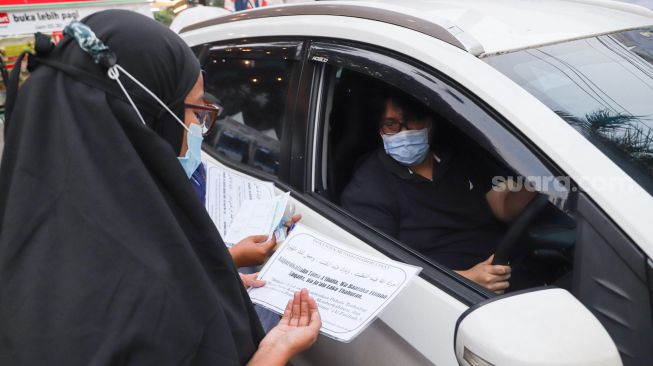 Warga membayar zakat secara drive thru di Masjid Nurul Hidayah, Tanah Kusir, Jakarta Selatan, Sabtu (8/5/2021). [Suara.com/Alfian Winanto]