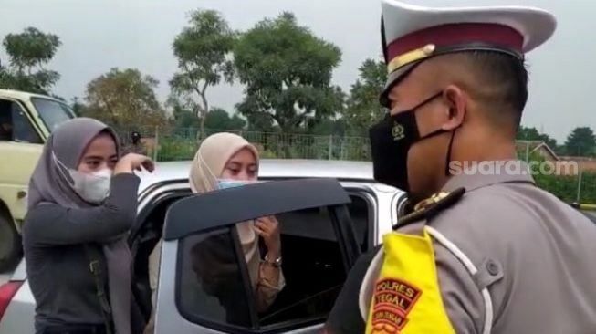 Pemudik yang ketahuan membawa surat rapid test antigen palsu menangis saat terjaring operasi penyekatan di Exit Tol Tegal, Adiwerna, Kabupaten Tegal, Sabtu (8/5/2021). [Suara.com/F Firdaus]