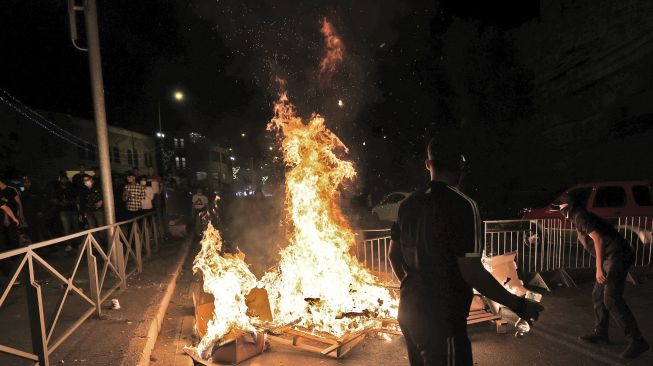 Pengunjuk rasa Palestina mendirikan barikade yang terbakar di Kota Tua Yerusalem, pada (8/5/2021). [EMMANUEL DUNAND / AFP]