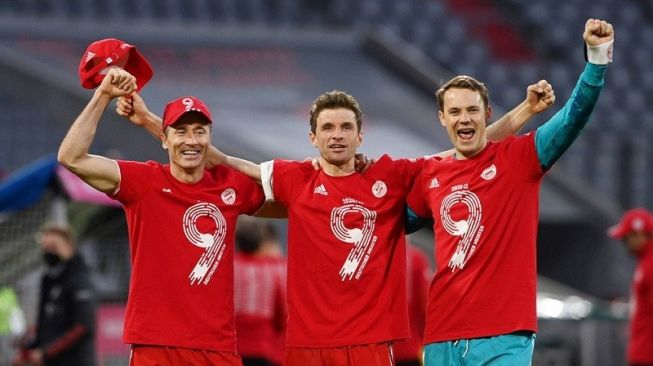 Para pemain Bayern Munich (ki-ka) Robert Lewandowski, Thomas Mueller dan Manuel Neuer melakukan selebrasi mengenakan kaos bersematkan angka sembilan, menandai gelar juara Liga Jerman yang mereka raih sembilan musim beruntun, selepas mengalahkan Borussia Moenchengladbach di Stadion Allianz Arena, Muenchen, Jerman, Sabtu (8/5/2021) waktu setempat. (ANTARA/REUTERS/POOL/Christof Stache)