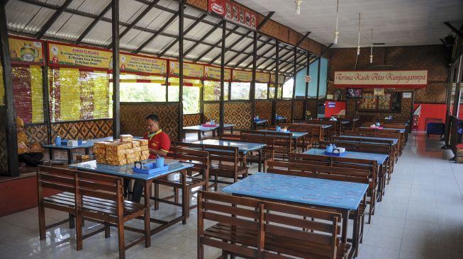 Seorang pekerja berada di sebuah rumah makan yang sepi di Nagreg, Kabupaten Bandung, Jawa Barat, Minggu (9/5/2021). [ANTARA FOTO/Raisan Al Farisi]