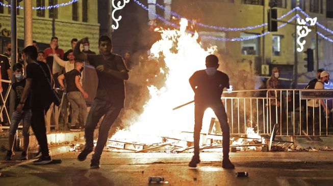 Pengunjuk rasa Palestina melemparkan batu ke pasukan keamanan Israel di tengah bentrokan di Kota Tua Yerusalem, pada (8/5/2021). [EMMANUEL DUNAND / AFP]