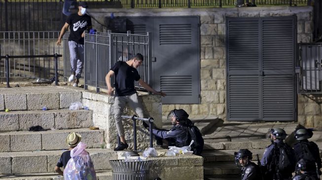 Pasukan keamanan Israel mencoba menahan seorang pengunjuk rasa Palestina di luar Gerbang Damaskus di Kota Tua Yerusalem, pada (8/5/2021). [EMMANUEL DUNAND / AFP]