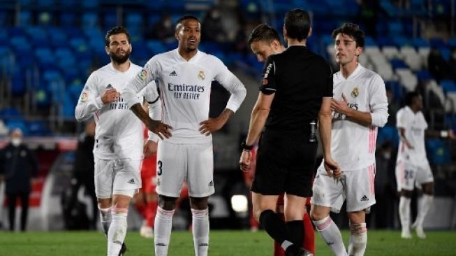 Pemain Real Madrid melayangkan protes kepada wasit usai membatalkan penalti dalam laga kontra Sevilla di Estadio Alfredo Di Stefano, Senin (10/5/2021). [AFP]