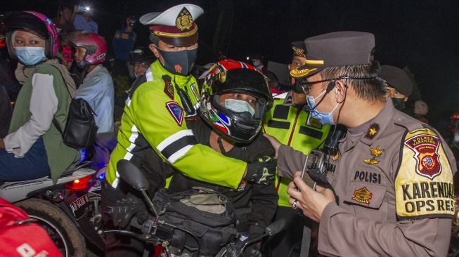 Polisi mengamankan pemudik motor yang memicu kerusuhan di jalur pantura Karawang, Jawa Barat, Senin (10/5/2021). [ANTARA FOTO/M Ibnu Chazar]