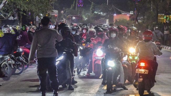 Petugas menghalau sejumlah pemudik motor yang melawan arah untuk menghindari posko penyekatan mudik di Kedungwaringin, Kabupaten Bekasi, Jawa Barat, Minggu (9/5/2021). [ANTARA/Fakhri Hermansyah]