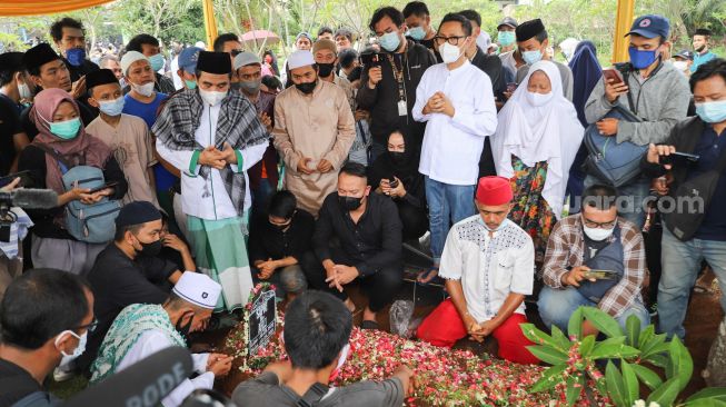 Keluarga dan kerabat berdoa diatas pusara komedian Sapri Pantun di TPU Ulujami, Pesanggrahan, Jakarta Selatan, Selasa (11/5/2021). [Suara.com/Alfian Winanto]