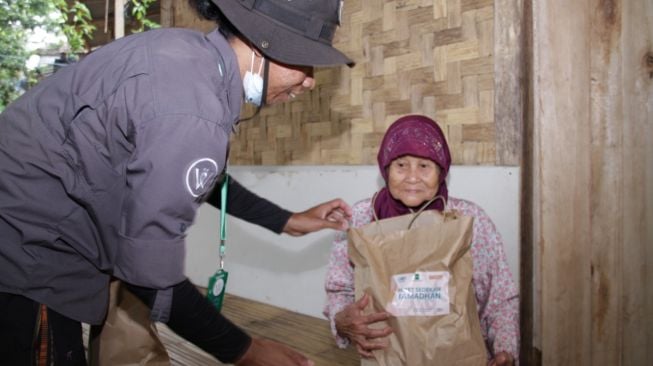 Seorang jompo di Kabupaten Lebak, Banten, menerima bantuan sembako dari tim Badan Wakaf Alquran. [dokumentasi pribadi]