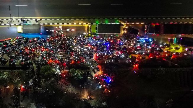 Seorang pengendara sepeda motor terjebak kemacetan saat melintasi pos larangan mudik di jalur Pantura Patokbeusi, Subang, Jawa Barat, Selasa (11/5/2021) dini hari.  ANTARA FOTO/M Ibnu Chazar