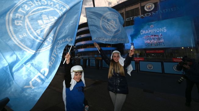 Seorang suporter Manchester City merayakan kemenangan klub kesayangannya menjadi juara Liga Premier Inggris di luar Stadion Etihad di Manchester, Inggris, Selasa (11/5/2021) waktu setempat. Paul ELLIS / AFP