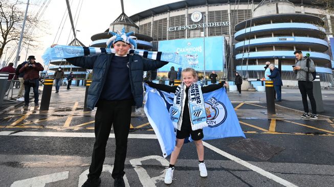 Seorang suporter Manchester City merayakan kemenangan klub kesayangannya menjadi juara Liga Premier Inggris di luar Stadion Etihad di Manchester, Inggris, Selasa (11/5/2021) waktu setempat. Paul ELLIS / AFP