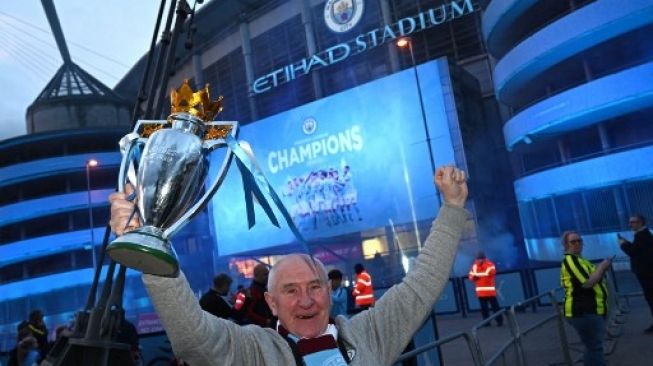 Para suporter Manchester City merayakan sukses timnya menjadi juara Premier League musim ini di luar Etihad Stadium setelah rival terdekatnya Manchester United kalah dari Leicester City. Paul ELLIS / AFP