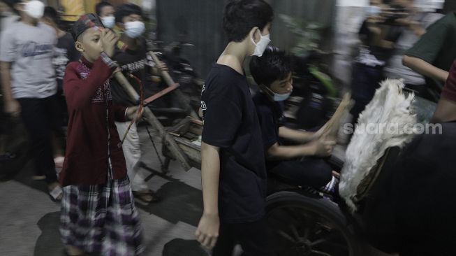 Sejumlah anak menabuh beduk saat takbir keliling di Kecamatan Sawah Besar, Jakarta, Rabu (12/5/2021). [Suara.com/Angga Budhiyanto]