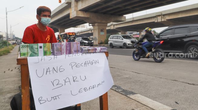 Penjual jasa penukaran uang baru menunggu pembeli di Kalimalang, Jakarta Timur, Rabu (12/5/2021). [Suara.com/Alfian Winanto]