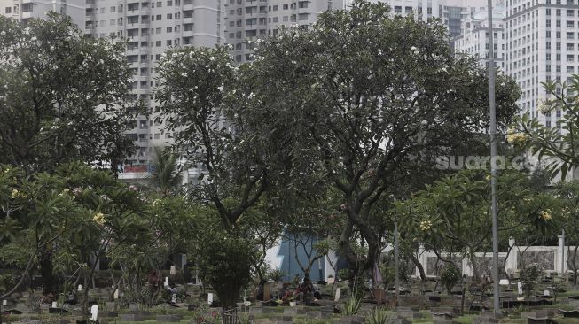 Petugas beristirahat di area makam di Tempat Pemakaman Umum (TPU) Karet Bivak, Jakarta, Rabu (12/5/2021). [Suara.com/Angga Budhiyanto]