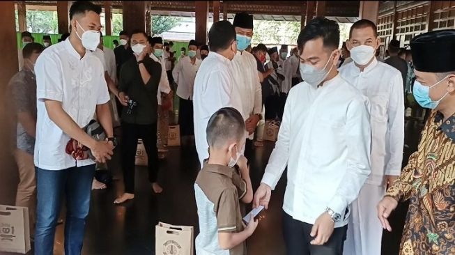 Wali Kota Solo, Gibran Rakabuming Raka (ketiga dari kanan) menyerahkan “uang fitrah” kepada anak yang mengikuti Salat Idul Fitri di Pendapi Gede Balai Kota Solo, Kamis (13/5/2021). [Solopos.com/Kurniawan]