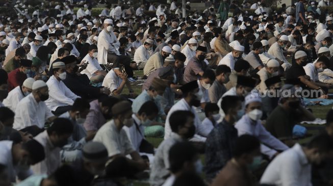 Umat Muslim mendengarkan khotbah sebelum menunaikan ibadah Salat Idul Fitri 1442 H di lingkungan Masjid Al-Azhar, Jakarta, Kamis (13/5/2021). [Suara.com/Angga Budhiyanto]