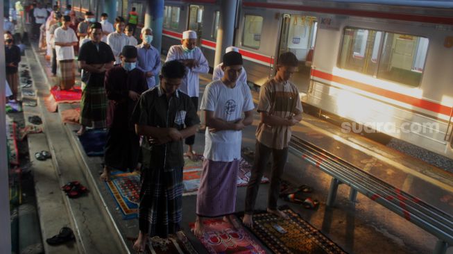 Sejumlah umat Islam melaksanakan Shalat Idul Fitri di peron Stasiun KA Kampung Bandan, Jakarta, Kamis (13/5/2021). [Suara.com/Dian Latifah]