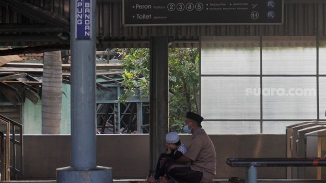 Umat Islam mendengarkan khotbah usai melaksanakan Shalat Idul Fitri di peron Stasiun KA Kampung Bandan, Jakarta, Kamis (13/5/2021). [Suara.com/Dian Latifah]