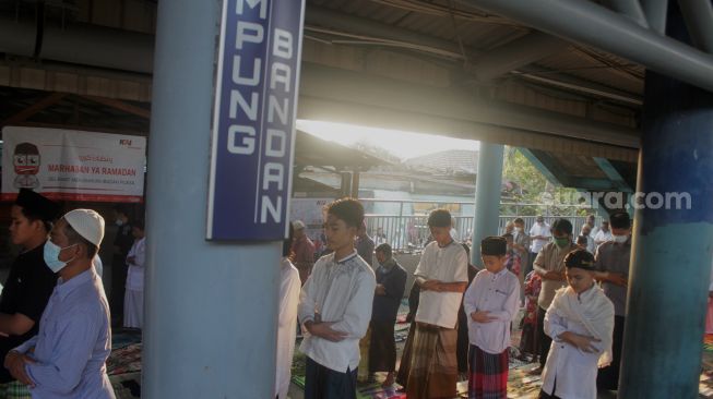 Sejumlah umat Islam melaksanakan Shalat Idul Fitri di peron Stasiun KA Kampung Bandan, Jakarta, Kamis (13/5/2021). [Suara.com/Dian Latifah]