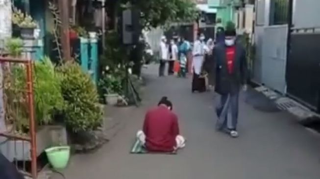Tangkapan layar video viral seorang pemuda ketiduran di jalanan saat Salat Idul Fitri sudah selesai. [Instagram]