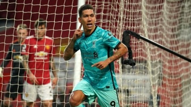 Selebrasi penyerang Liverpool, Roberto Firmino usai membobol gawang Manchester United. (DAVE THOMPSON / POOL / AFP)