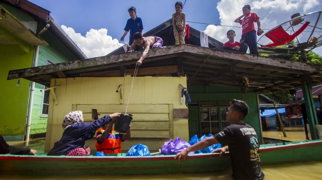 Sejumlah relawan mendistribusikan bantuan makanan kepada warga yang terdampak banjir di Jalan Biduri, Kecamatan Satui, Kabupaten Tanah Bumbu , Kalimantan Selatan, Sabtu (15/5/2021). [ANTARA FOTO/Bayu Pratama S]